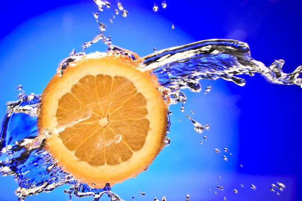 Vista de cerca de la pieza de naranja en rodajas que se salpica con agua —  Fotos de Stock