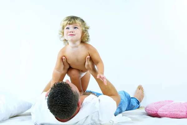 High key portrait of a young man playing with his baby daughter