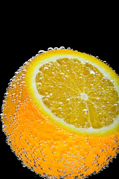 Syn på färska orange skiva på svart rygg — Stockfoto