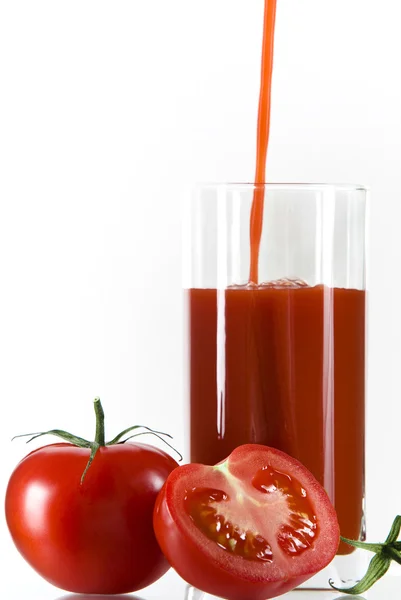 Vista de buenos tomates rojos y un vaso de jugo al lado — Foto de Stock