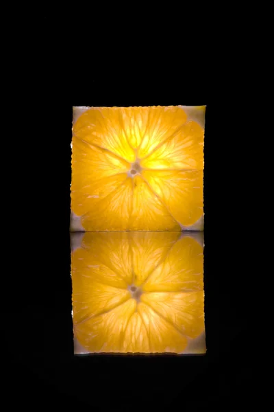 Pohled čerstvý plátek pomeranče na černý zadní — Stock fotografie