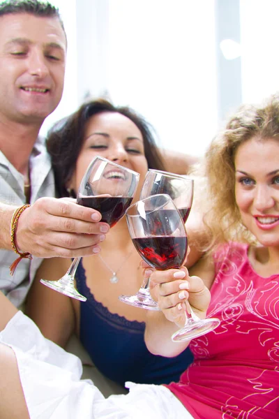 Porträt junger glücklicher Menschen, die Wein trinken — Stockfoto