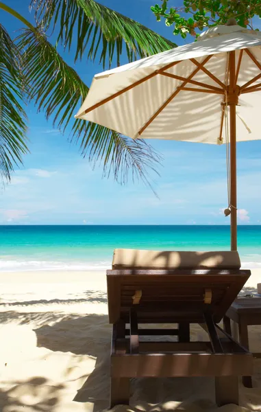 Blick auf Stuhl und weißen Sonnenschirm am tropischen Strand. — Stockfoto