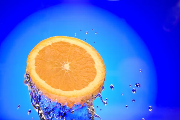 Nahaufnahme von aufgeschnittenen Orangenstücken, die mit Wasser bespritzt werden — Stockfoto