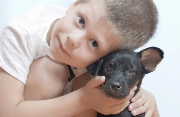 Портрет маленького мальчика, развлекающегося со своим щенком — стоковое фото