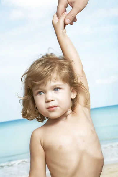 해변 주위에 손가락을 이끄는 좋은 작은 소녀의 초상화 — 스톡 사진