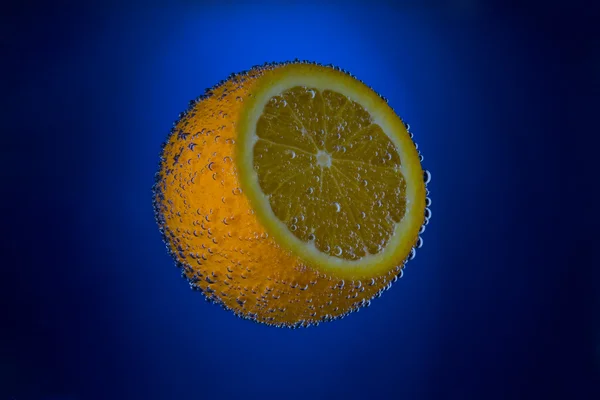 Limão suculento fresco fazendo bolhas na água — Fotografia de Stock