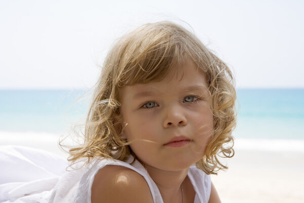 Portrait of nice little girl having fun on the beach