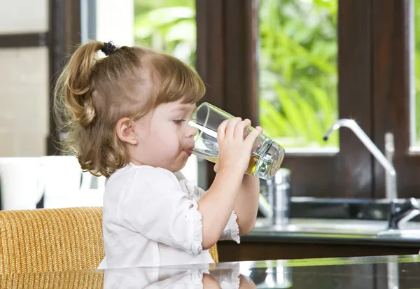 Porträtt av liten flicka som dricker i hemmiljö — Stockfoto