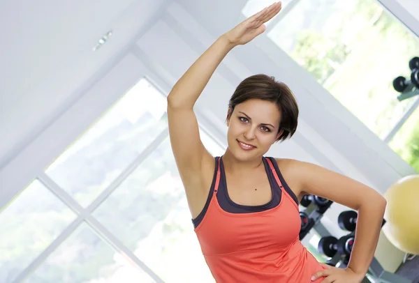 Porträt einer jungen netten Frau, die im Fitnessstudio beschäftigt ist — Stockfoto