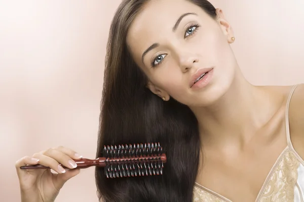 Retrato de bela jovem mulher ficando ocupado com seu cabelo — Fotografia de Stock