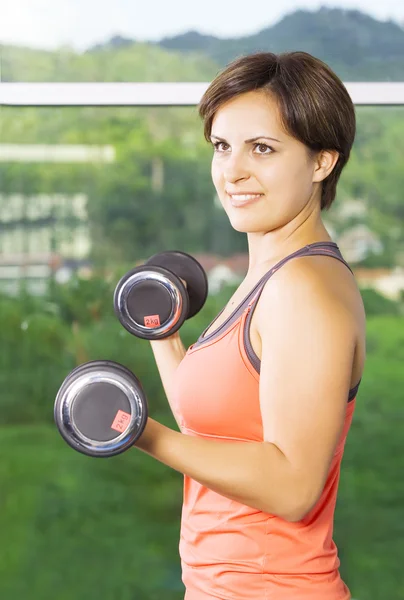Portrait of young nice woman getting busy in gym — Stock Photo, Image