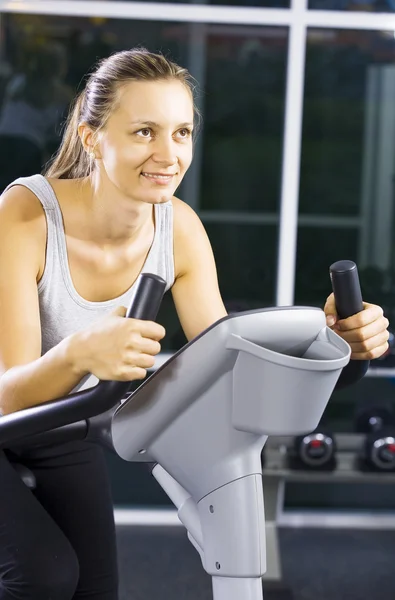 Portrait of young woman getting busy in gym — Stock Photo, Image