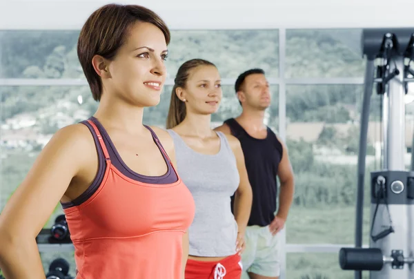 Porträtt av ung trevlig bli upptagen i gym — Stockfoto