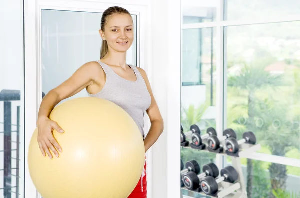 Porträt einer jungen netten Frau, die im Fitnessstudio beschäftigt ist — Stockfoto