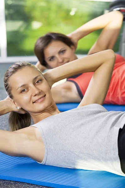 Porträt junger netter Frauen, die im Fitnessstudio beschäftigt sind — Stockfoto