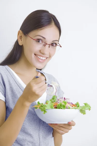 Portret van jonge mooie brunette met plantaardige salade — Stockfoto