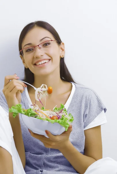 Portrait of young beautiful brunette with vegetable salad — Stock Photo, Image