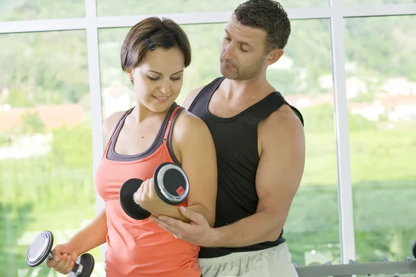 Portrait of young nice couple getting busy in gym — Stock Photo, Image