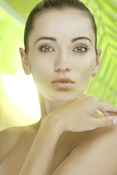 Portrait of young beautiful woman on green leafs back — Stock Photo, Image