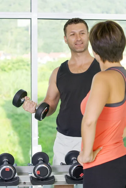 Portrait of young nice couple getting busy in gym — Stock Photo, Image