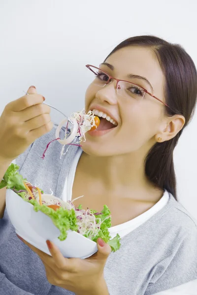 Portrait of young beautiful brunette with vegetable salad Royalty Free Stock Photos