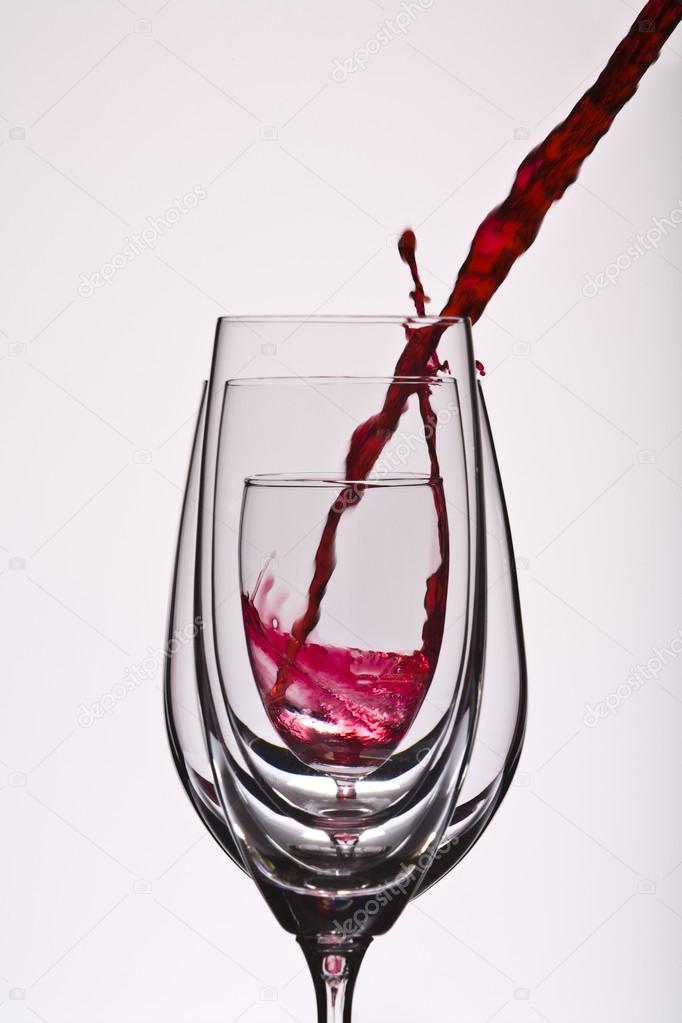 Close up view of wine glass getting filled on white back