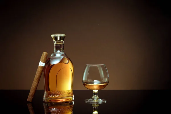 Close Zicht Sigaar Fles Cognac Een Glas Opzij Kleur Terug — Stockfoto