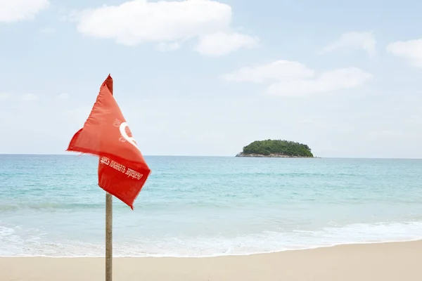 View of warning flag on nice warm tropic beach during law season