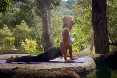 Tropik ortamda yoga yapan genç bir kadının portresi
