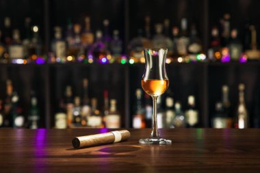 Closed up view of glass of rum with cigar on color back