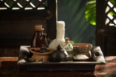 close up view of herb, salt, oil and Herbal Compress on color back.