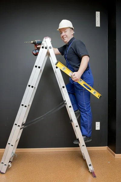 Werknemer permanent op een ladder — Stockfoto
