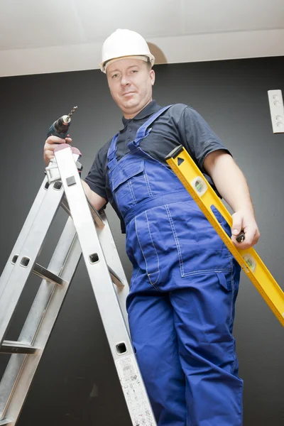 Trabajador de pie en una escalera — Foto de Stock