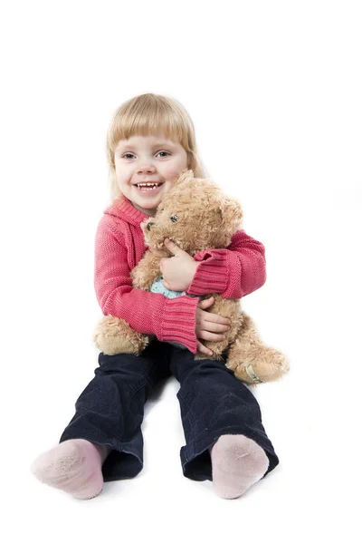 Little girl sits with a teddy bear — Stock Photo, Image