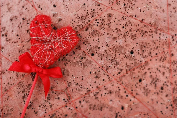 Красное сердце на фоне красного бетона — стоковое фото