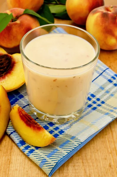 Молочный коктейль с персиком на салфетке — стоковое фото