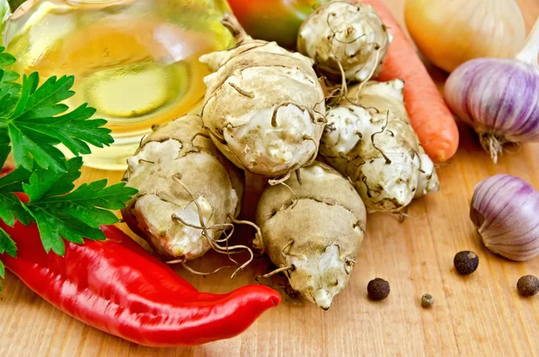 Alcachofas de Jerusalén con verduras y aceite a bordo —  Fotos de Stock