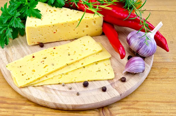 Cheese with spices and herbs on a round board — Stock Photo, Image