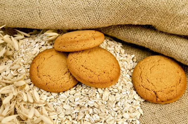 Oatmeal cookies with oatmeal on sacking — Stock Photo, Image