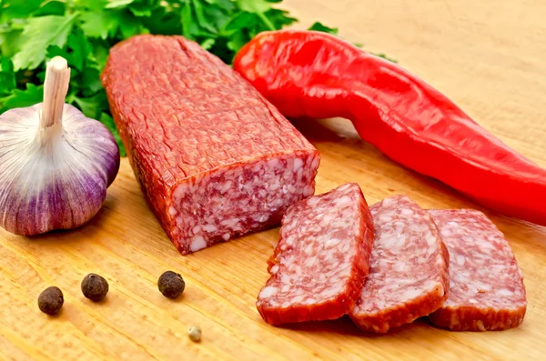 Salami with vegetables on the board — Stock Photo, Image