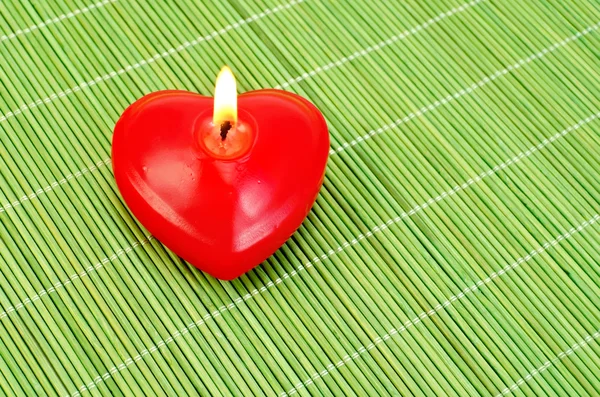 Сердце свечей на зеленом бамбуке — стоковое фото