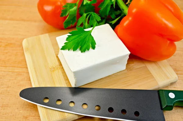 Sebze ve bir bıçak ile bir tahta üzerinde beyaz peynir — Stok fotoğraf