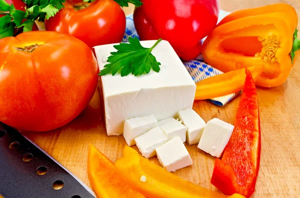 Feta cheese with vegetables on the board — Stock Photo, Image