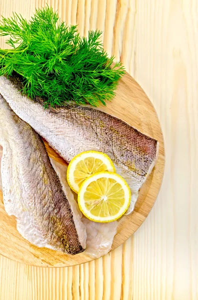 Filete de bacalao en un plato redondo con limón — Foto de Stock