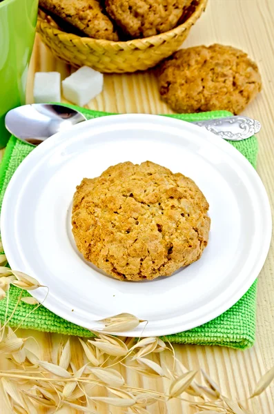 Biscuits with stalks of oats on a wooden board — Stock Photo, Image