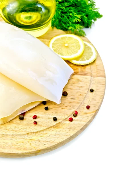 Calamar con limón y aceite en una tabla redonda — Foto de Stock