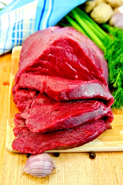 Мясо говядины на деревянной доске с чесноком — стоковое фото