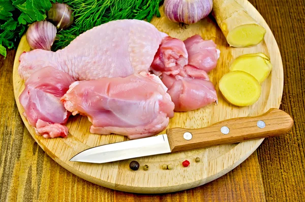 Chicken leg cut on a wooden board with a knife — Stock Photo, Image