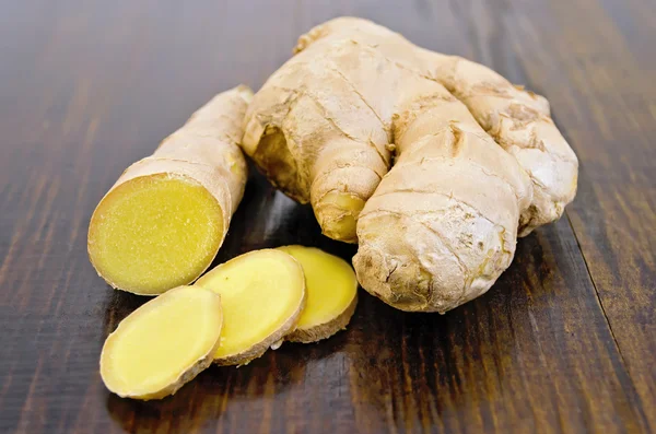 Ginger root cut into the dark board — Stock Photo, Image